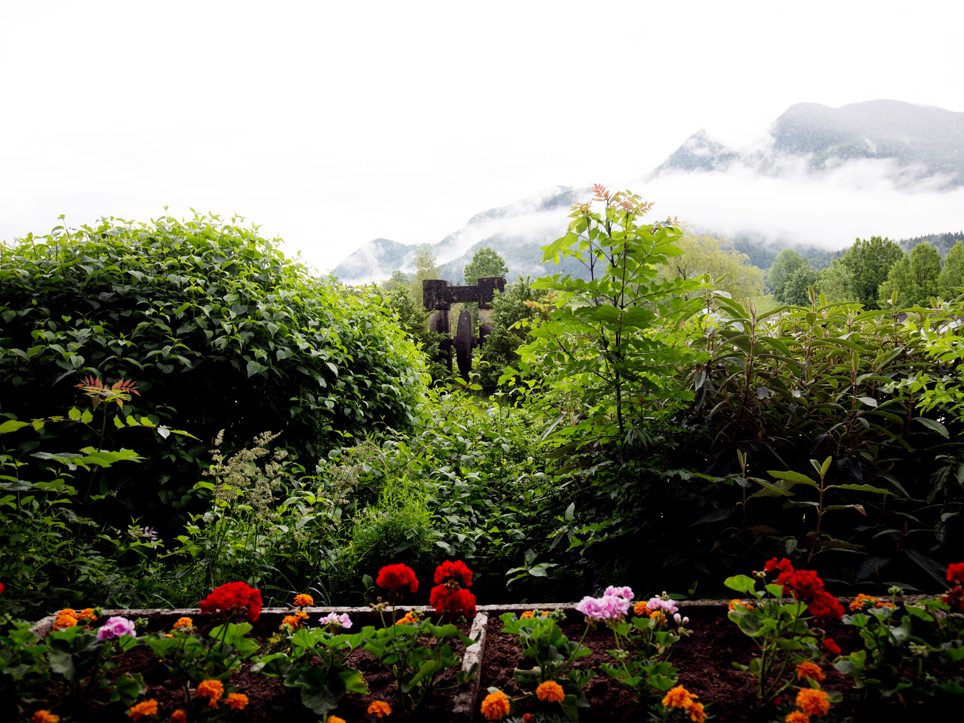 Garten mit Blumenbeet dahinter Berge